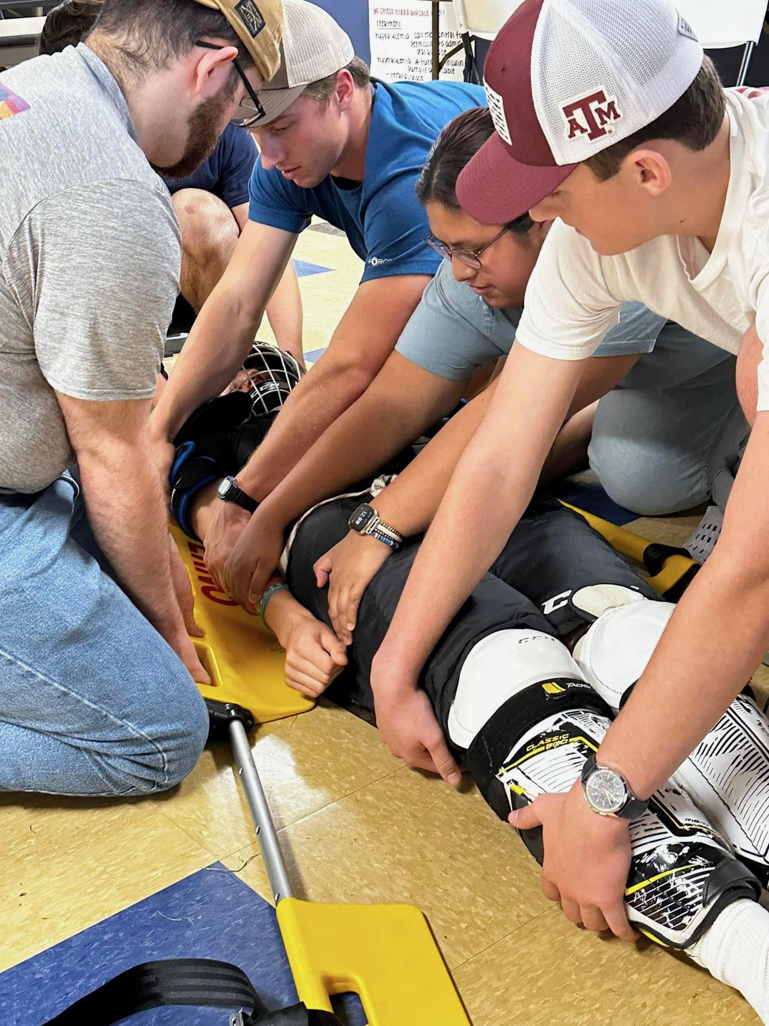 Students practicing patient immobilization during EMS training
