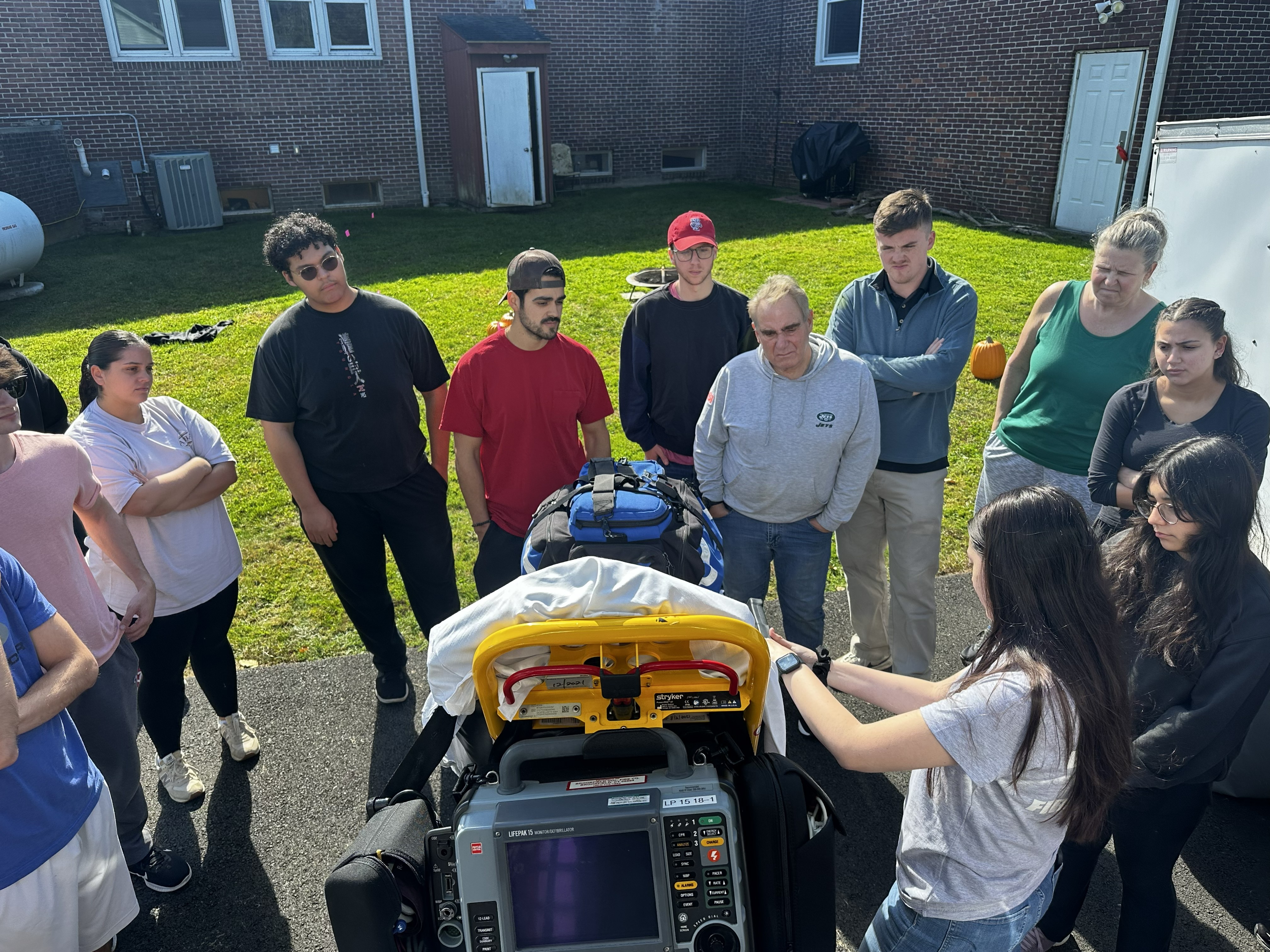 Class gathered around emergency medical equipment outdoors